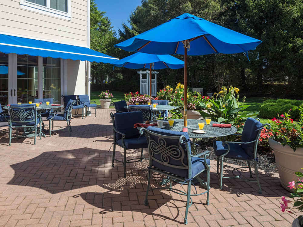 Community patio with shaded seating and a table set with light bites