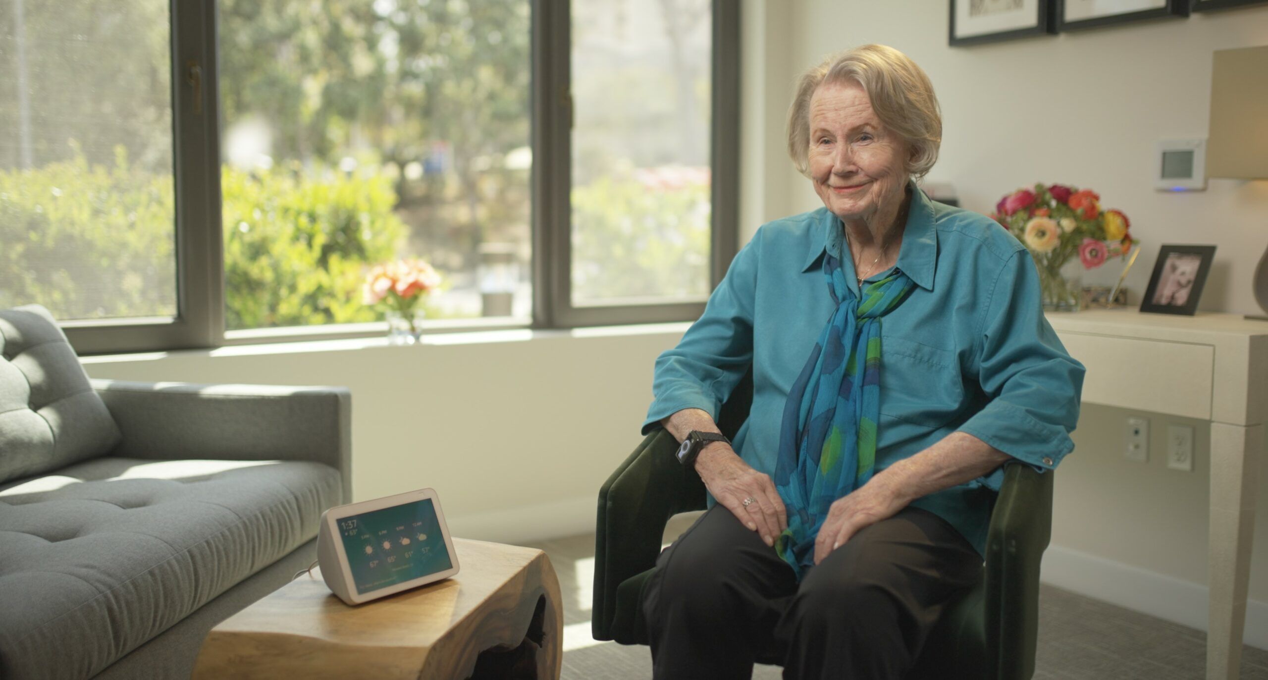 Senior woman sitting next to an Amazon Alexa device