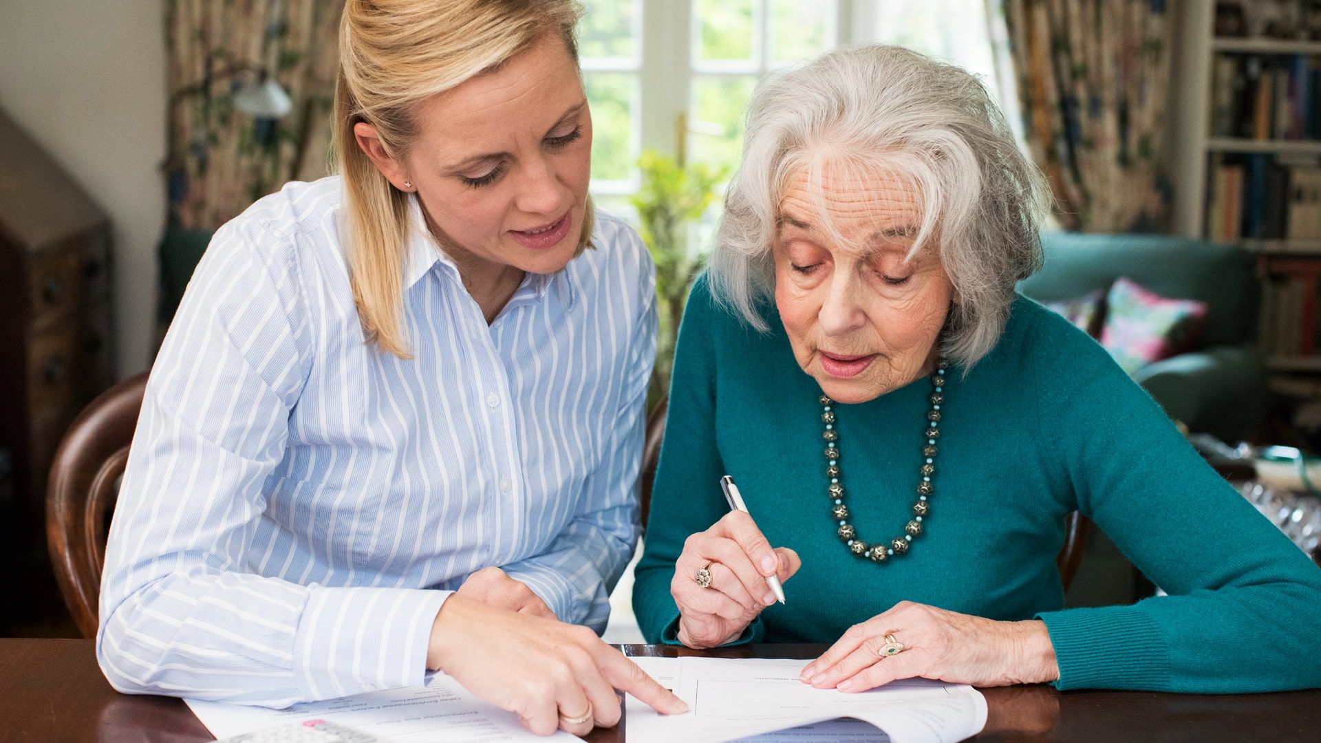 Older adult and adult daughter working together on power of attorney paperwork