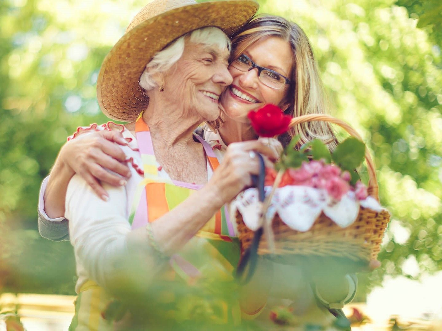 Senior woman and daughter hugging while spending time gardening