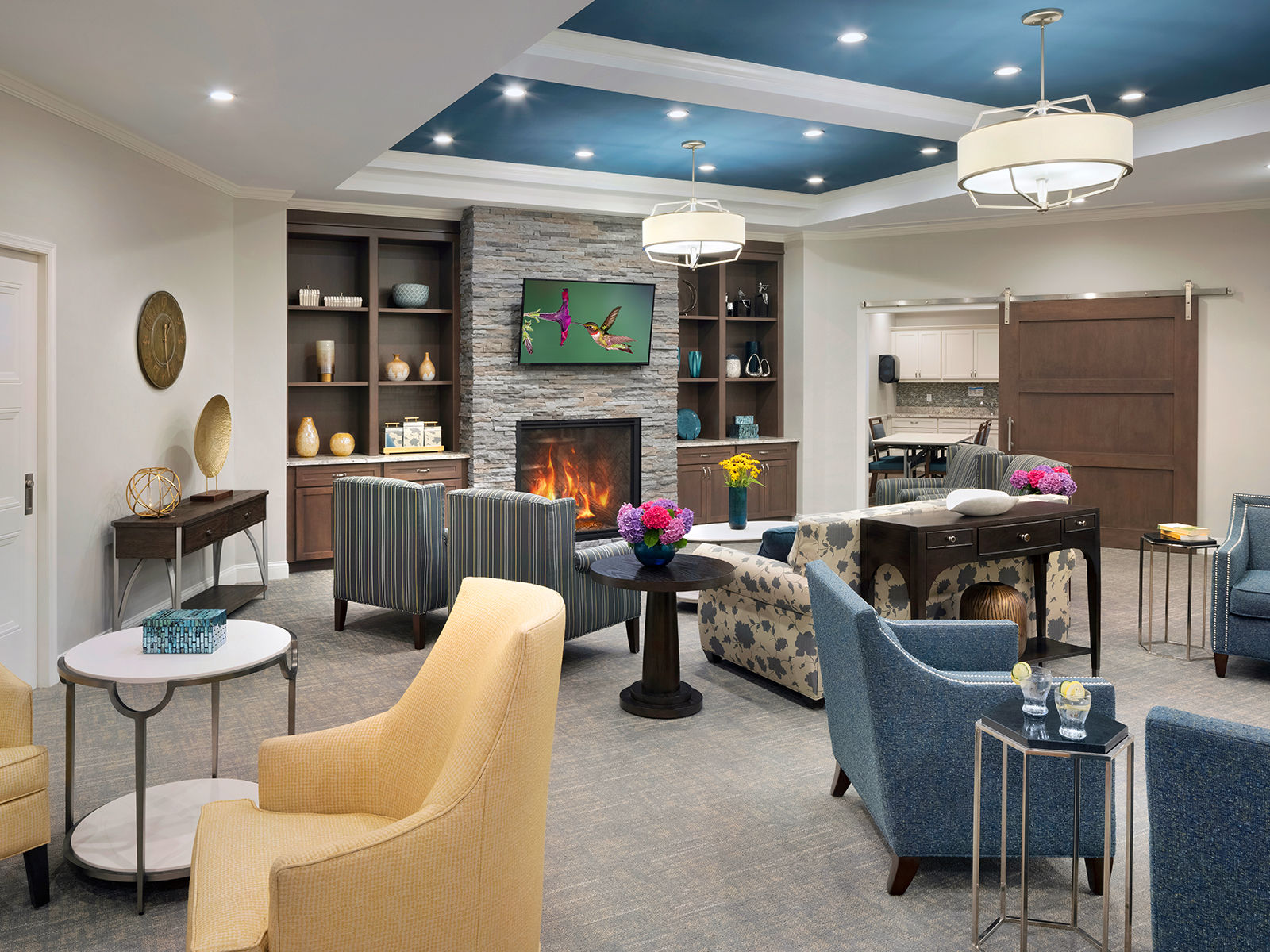 Community living room and lounge with plentiful seating and dark blue and yellow decor