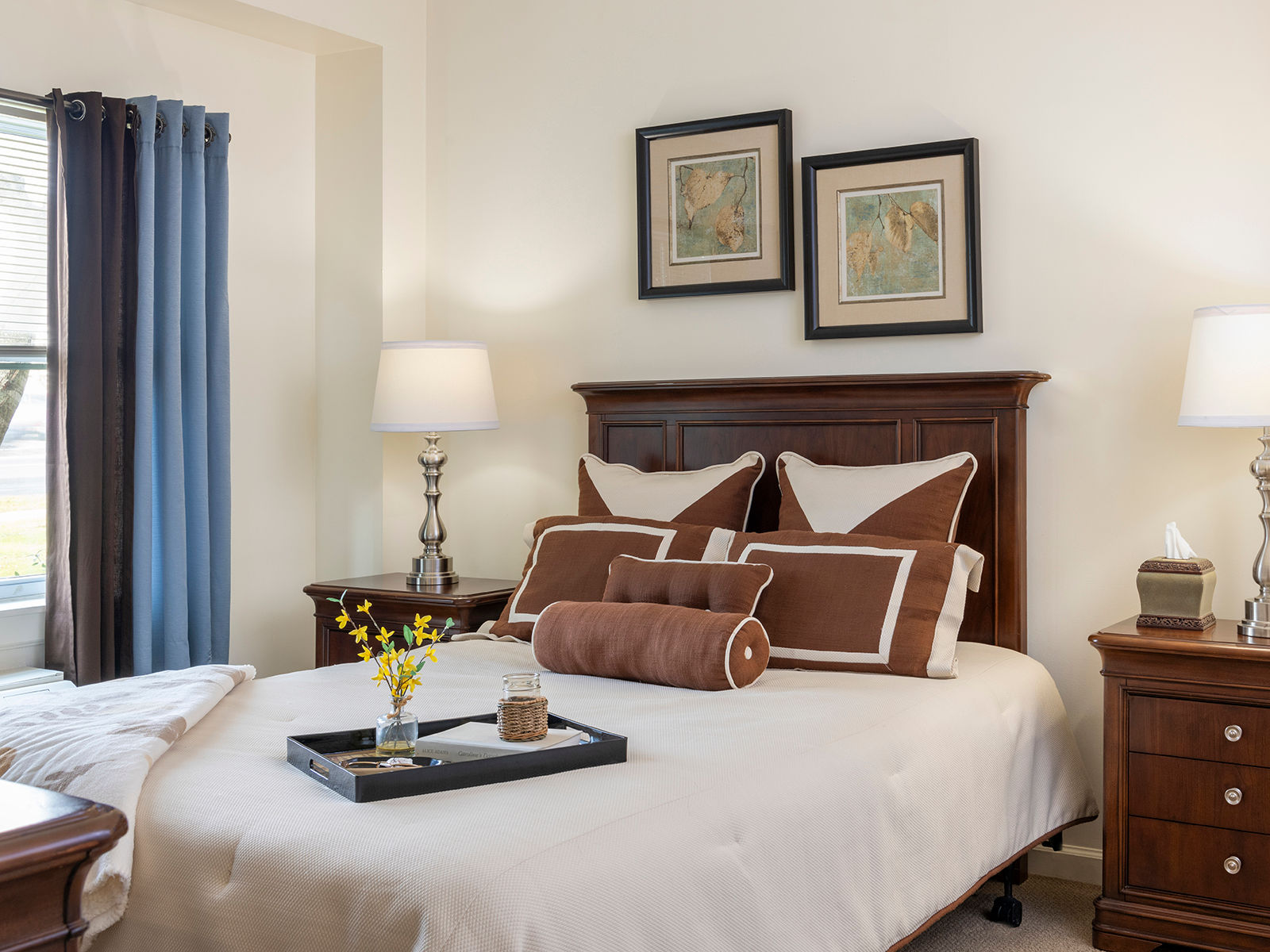 Apartment bedroom with a serving tray on the bed alongside comfortable pillow decorations