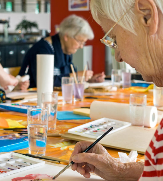 Senior woman painting during an art class