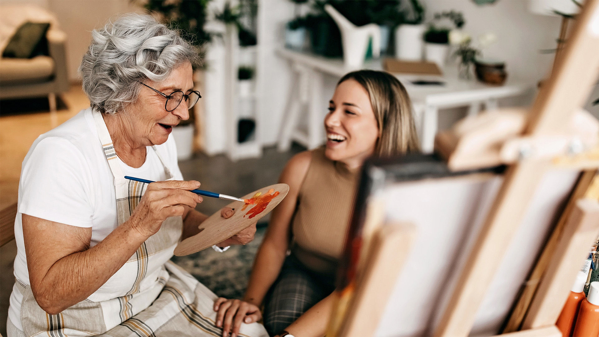 Young woman and senior woman painting together