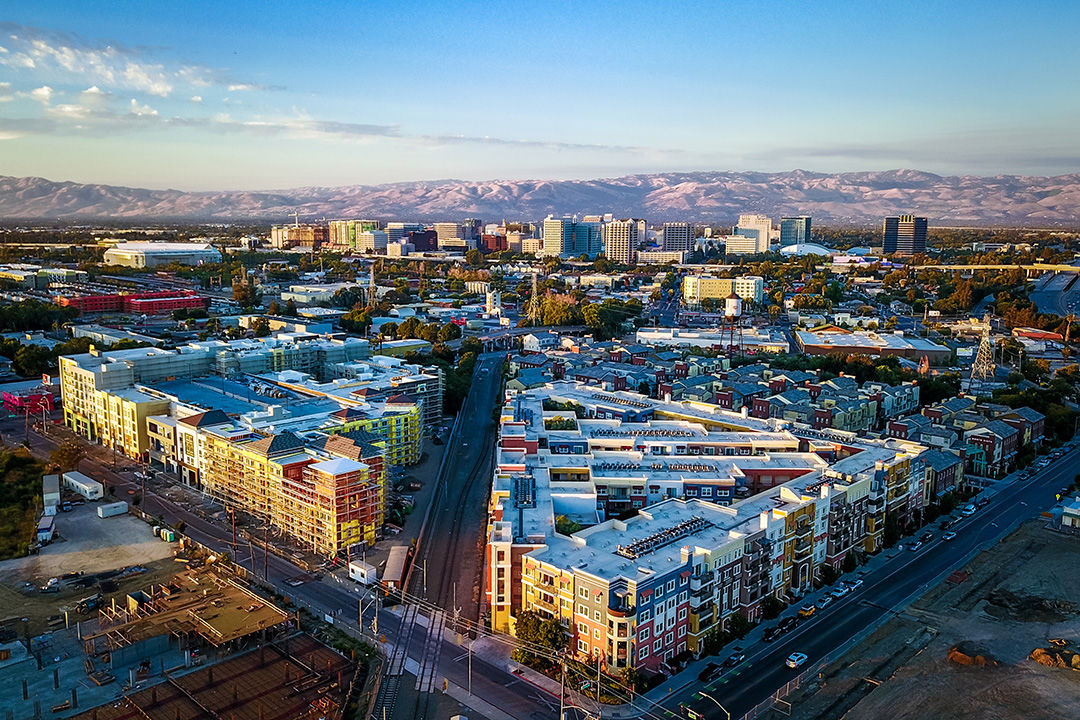 Urban setting of San Jose, California, with residential and businesses with mountains in the background.