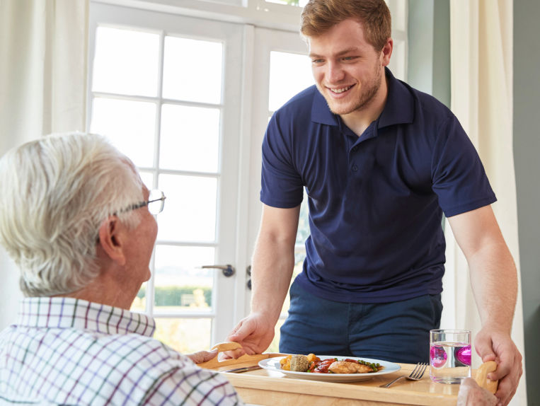 Holiday employee serving resident dinner