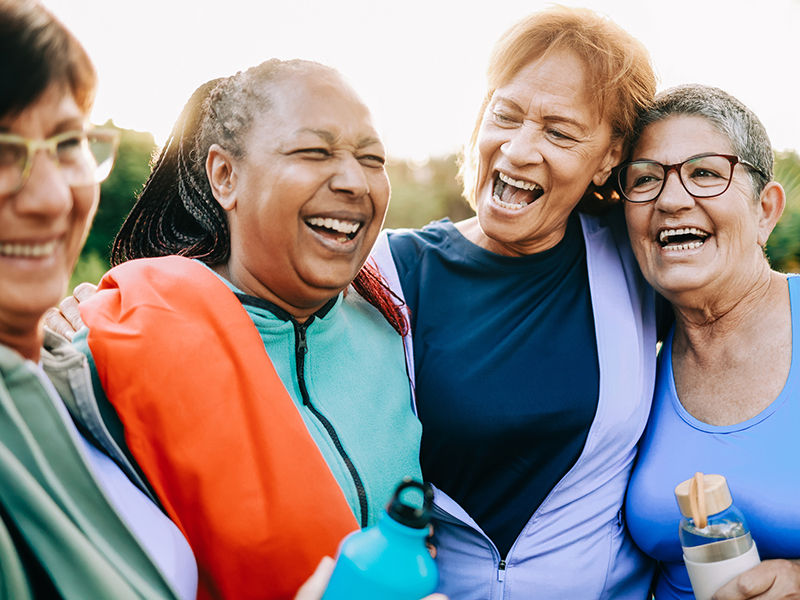 Sporty multiracial senior women having fun together after exercising and working out outdoors at a city park