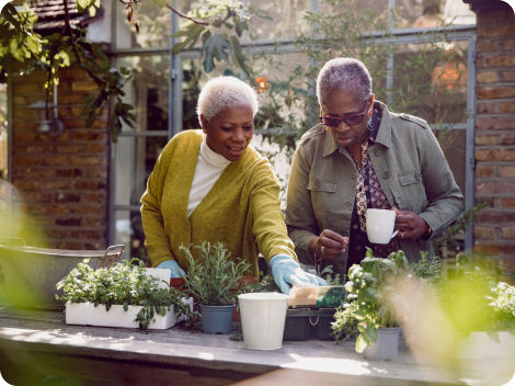 Two senior residents gardening outdoors on terrace