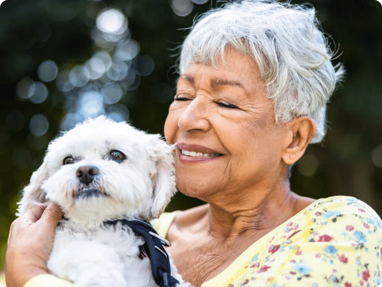 senior woman smiling while holding her small dog