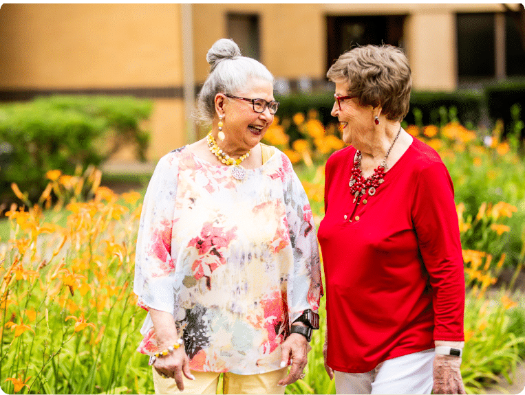 Two women talk and laugh in a field of tiger lilies