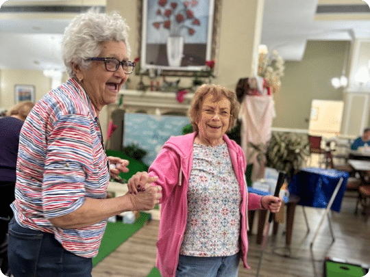 Two older woman dancing and laughing