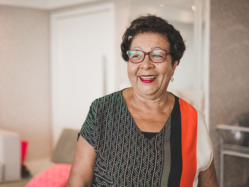 Femme âgée souriante et debout dans le salon