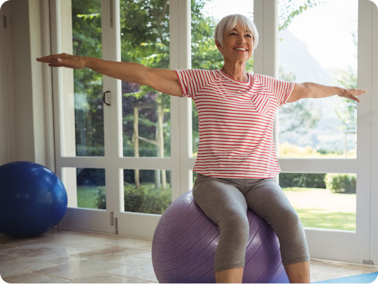 Older woman improving strength while sitting on an exercise ball
