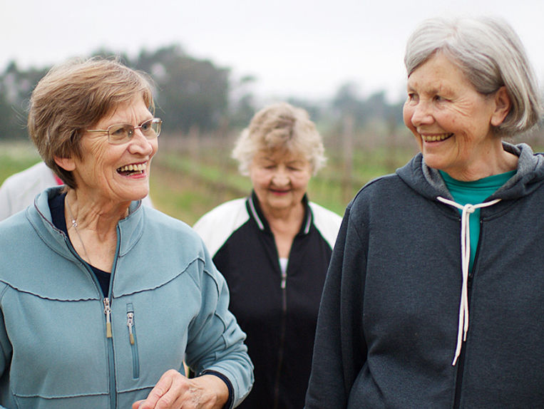 Three senior women in sweats walking in the outdoors