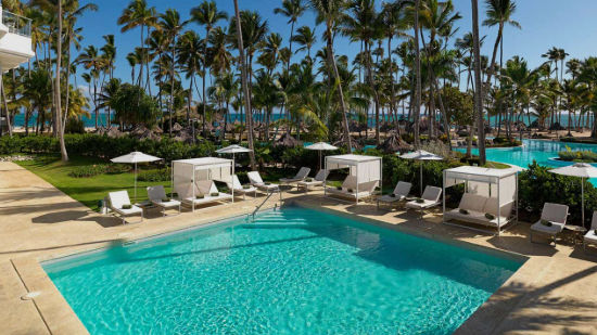 Piscina privada y área de relajación de lujo en The Level at Meliá Punta Cana Beach Resort, con cabañas exclusivas, tumbonas y un bosque de palmeras cocoteras frente al mar Caribe.