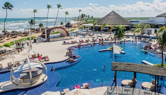 Vibrant and luxurious main swimming pool at the adults-only Royalton CHIC Punta Cana resort, featuring lounging areas and a social atmosphere.