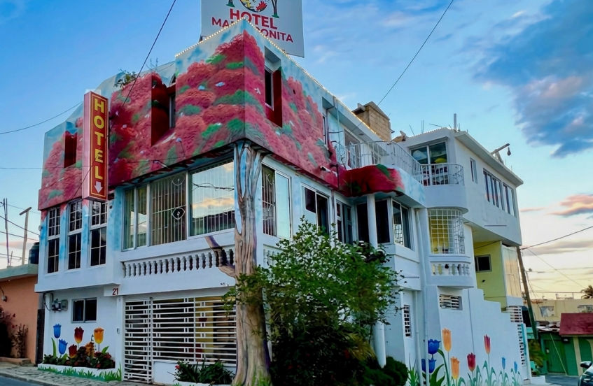 Modern design hotel facade featuring glass balconies and tropical palm trees at the entrance in Higuey Dominican Republic