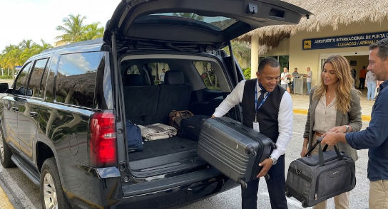 Chofer de Taxi Dominicana ayudando con las maletas en el aeropuerto de Punta Cana