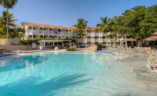Fachada principal del hotel Presidential Suites by Lifestyles con piscina tropical en Punta Cana