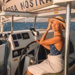 A woman at the helm of a catamaran