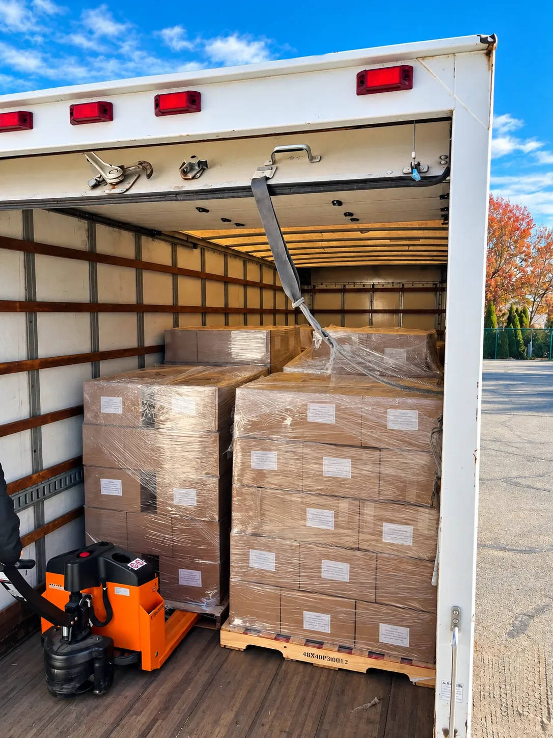 Wrapped pallets loaded and ready to roll, with the pallet jack on board.