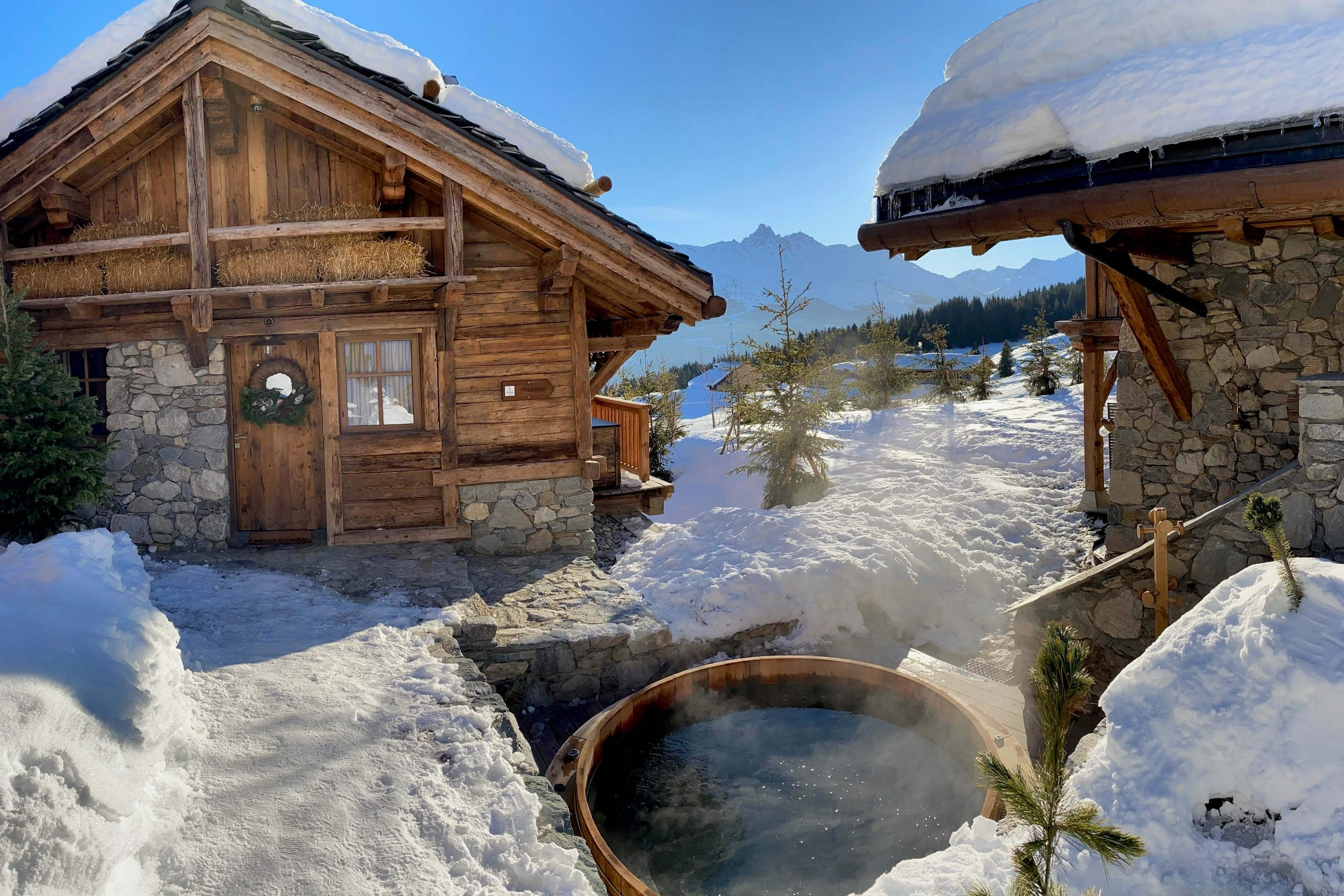 Outdoor cedar hot tub with mountain views and stone path access