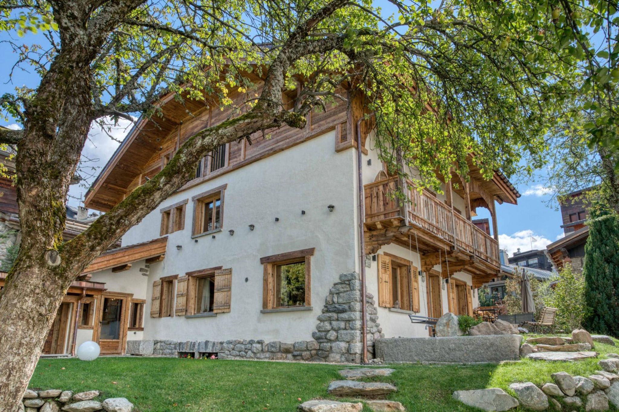 Chalet exterior featuring wrap-around balcony and private lawn with stone path