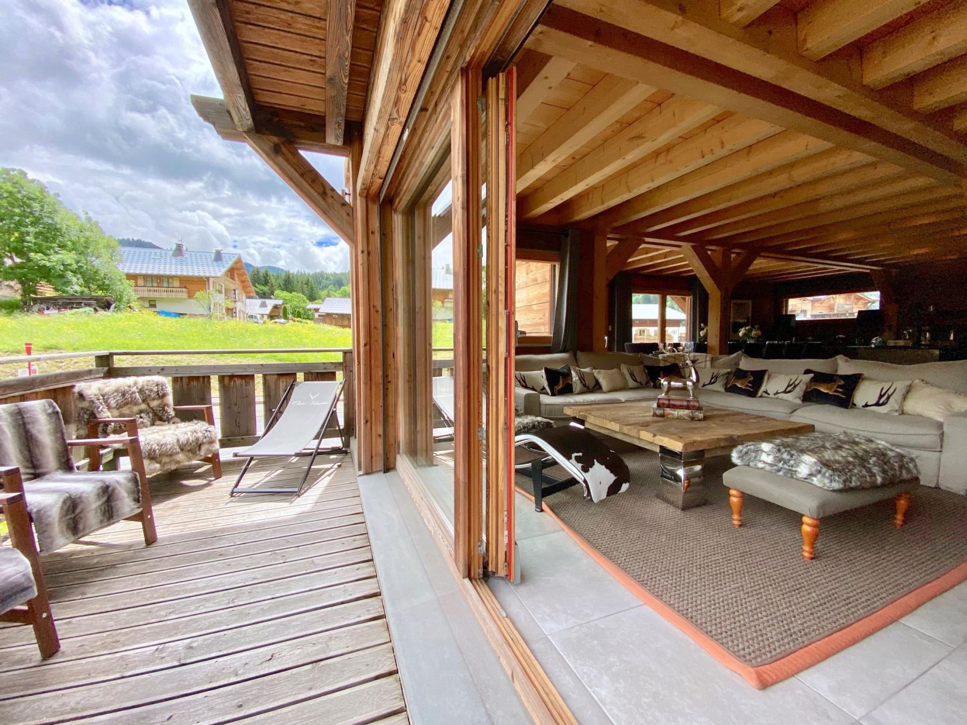 Living area with retractable glass wall opening to a timber balcony