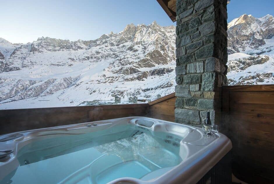 Outdoor hot tub on balcony with mountain views