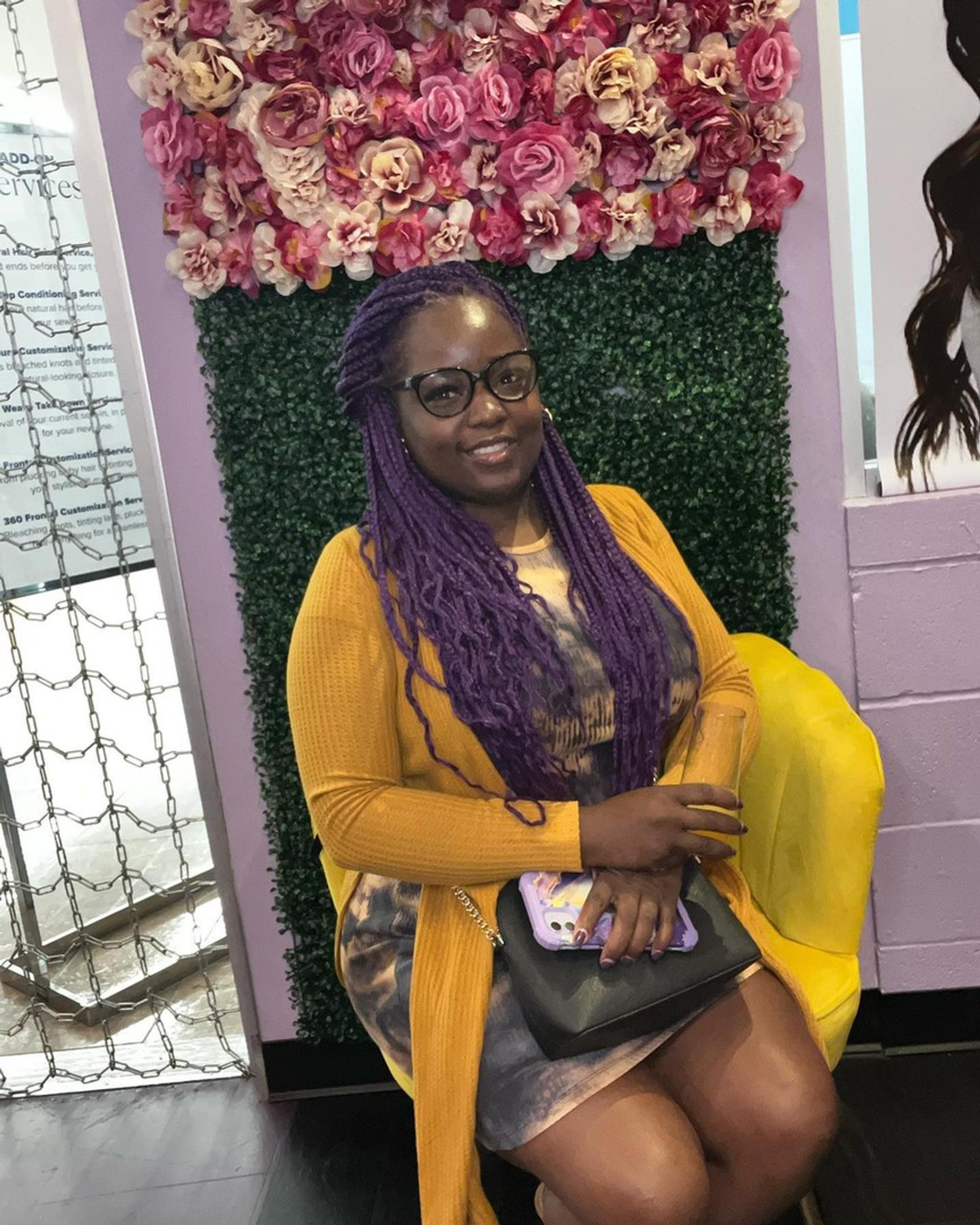 person,seated,floral background,yellow chair,glasses