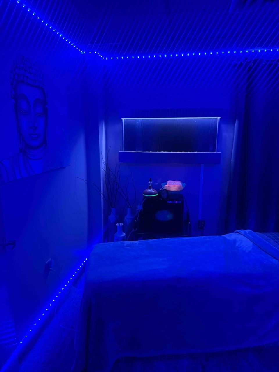 spa room,relaxation,blue lighting,massage table,calm atmosphere