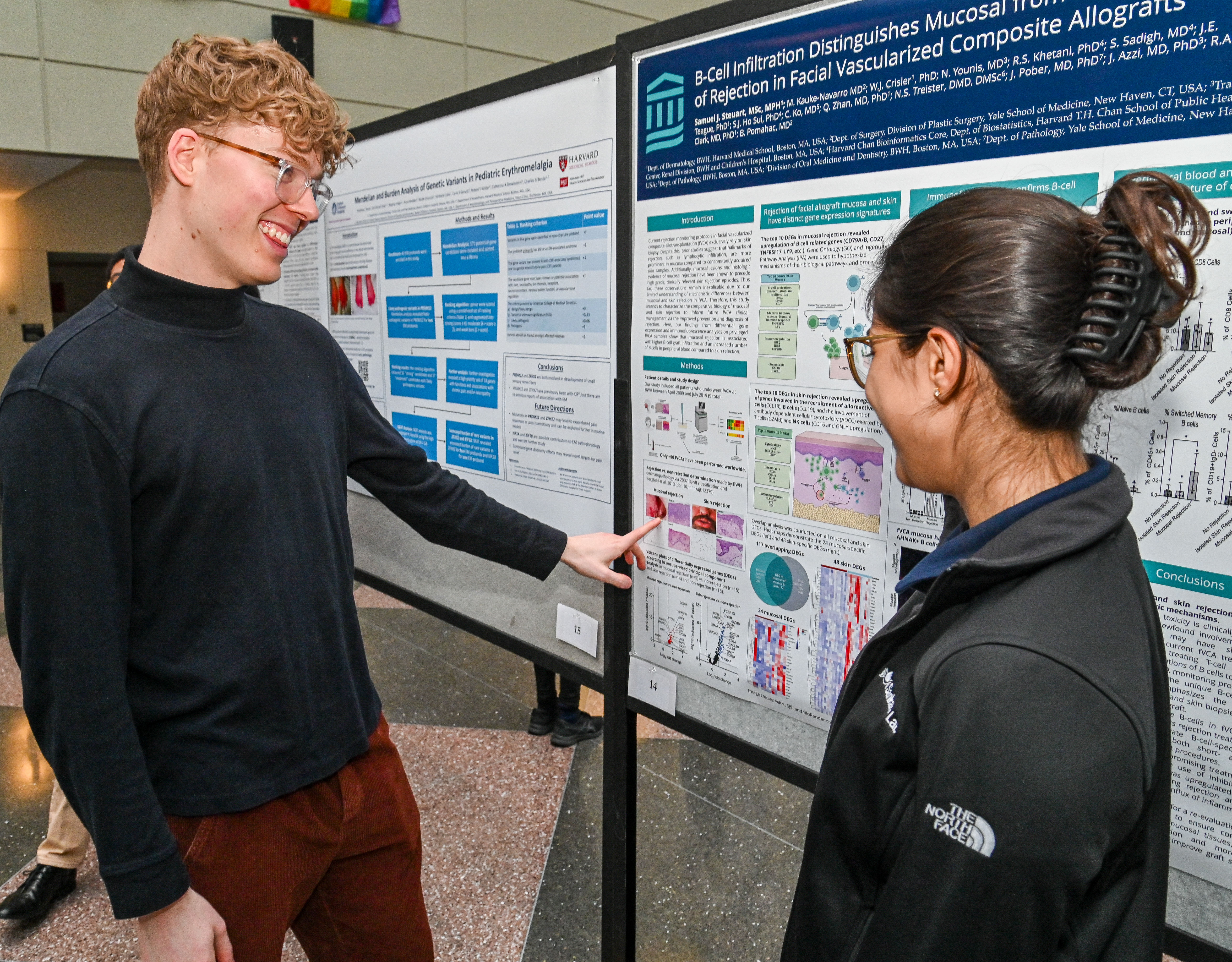 Photo of two students revieiwing a research poster at Som Weis research day.