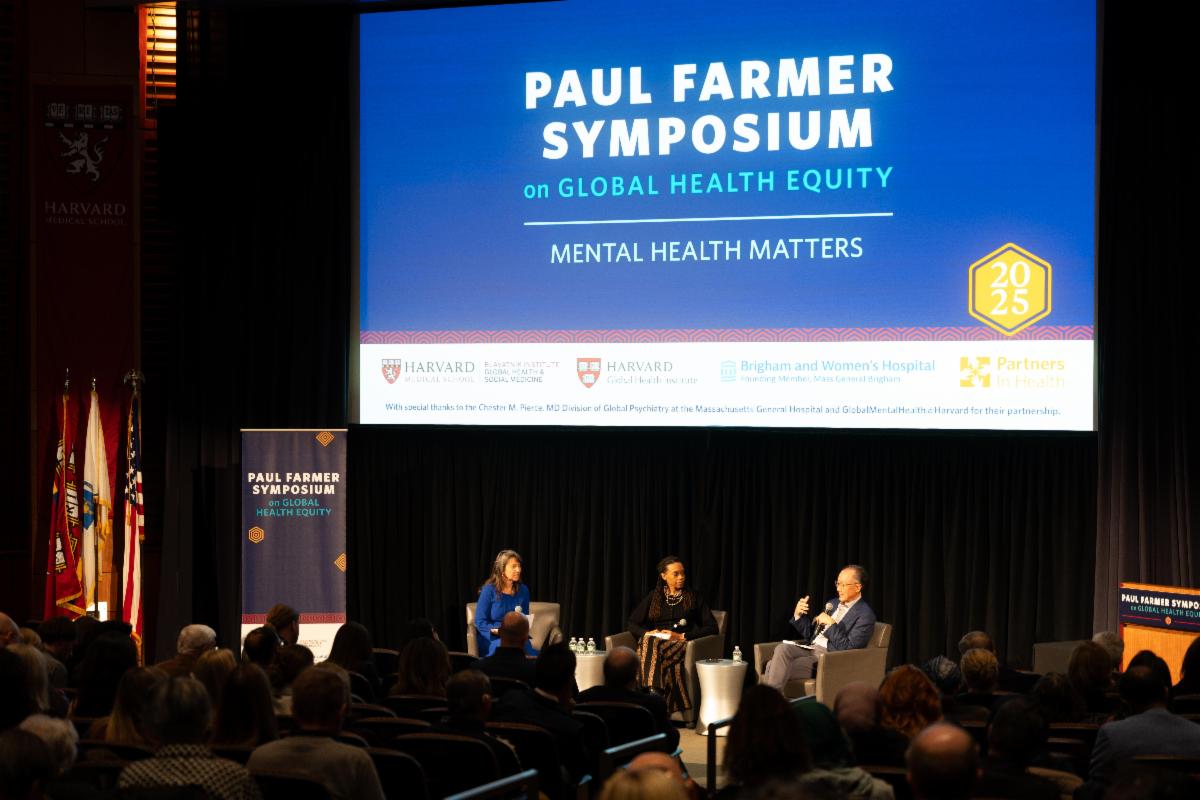 Panelists sitting on stage, conversing at the Paul Farmer Symposium