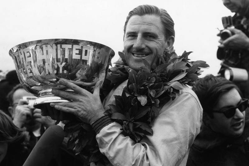 Graham Hill, BRM P261, holds his winner's trophy aloft.