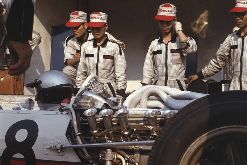 Richie Ginther (Honda RA273) is discussed by the mechanics.