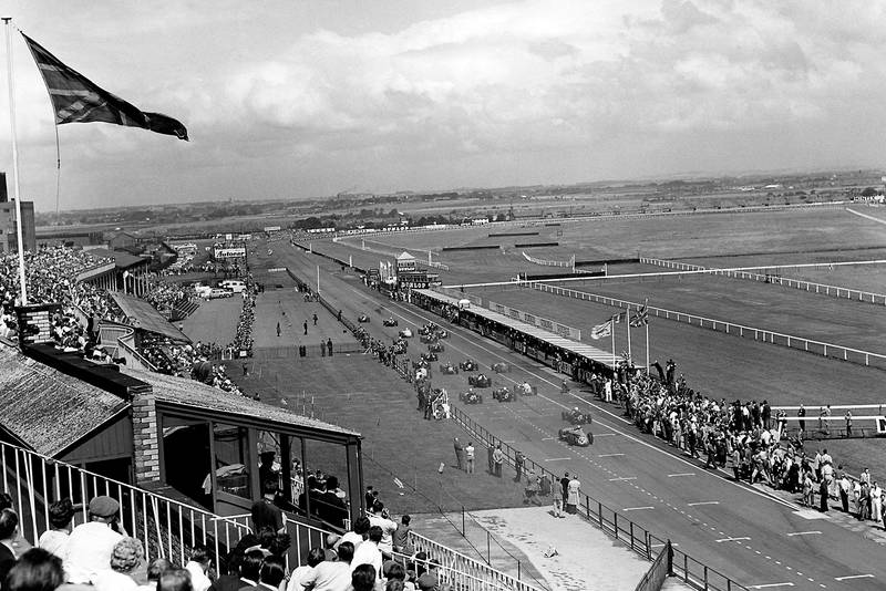Stirling Moss in the BRM P25 passes Bruce McLaren in his Cooper-Climax T45.