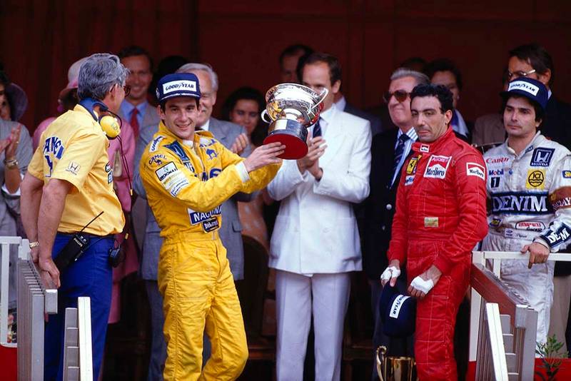 Ayrton Senna, 1st position, Michele Alboreto, 3rd position and Nelson Piquet, 2nd position on the podium. Lotus boss Peter Warr stands next to Senna to collect the constructors prize.