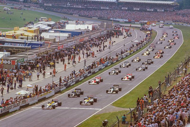 Nelson Piquet leads away from Nigel Mansell (both Williams FW11 Honda's), Ayrton Senna (Lotus 98T Renault) and Gerhard Berger (Benetton B186 BMW) at the start.