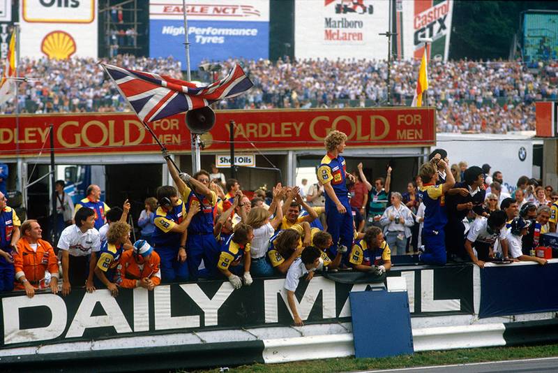 Williams team on the pit wall cheering home Nigel Mansell to 1st place.