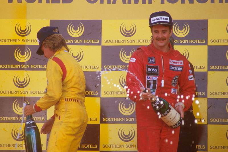 Nigel Mansell, 1st position and teammate Keke Rosberg, 2nd position celebrate on the podium.